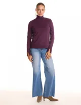 Polera de tejido fino, color rosado, con cuello alto, manga larga y detalle de tajo en los puños.