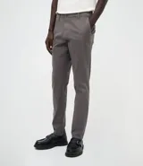 Pantalón slim de sarga lavada para hombre, de corte ajustado y color beige, con bolsillos laterales y traseros, trabillas para cinturón y cierre frontal con botón y cremallera.