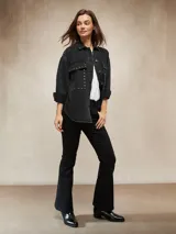 Jean de corte oxford en color negro, con tiro medio y ajuste en la cintura y caderas, ensanchándose desde la rodilla hacia el ruedo.