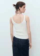 Top de punto fino con cuello en pico y tirantes finos, de diseño entallado y corte corto.