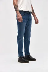 Jean de corte slim, con ajuste en cadera y muslos, y pierna levemente entallada desde la rodilla hasta el tobillo. Presenta un lavado azul medio clásico con costuras reforzadas.