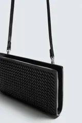 Cartera negra rectangular con diseño trenzado y correa fina para colgar.