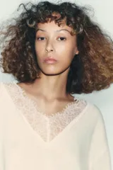 Jersey negro de manga larga con escote en V adornado con encaje negro.