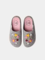Pantuflas de fieltro color gris, abiertas en el talón, con delicados bordados florales multicolores en el empeine y detalle de trenza de yute en la suela.