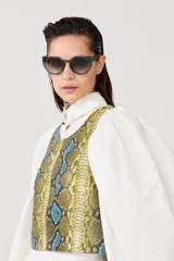 Top sin mangas confeccionado en cuero de oveja con estampado de piel de serpiente en tonos amarillo, azul y negro.