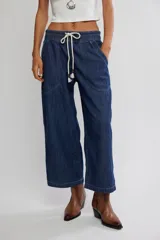 Jean azul de tiro medio con cintura elástica ajustable mediante cordón, bolsillos plaqué delanteros y diseño de pernera ancha y holgada.