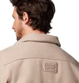 Campera tipo sobrecamisa Columbia de estilo retro, confeccionada en tejido de textura suave color beige. Presenta cierre frontal con botones, cuello clásico, dos bolsillos frontales con solapa y un anillo en D metálico en el bolsillo derecho. Incluye etiqueta de la marca en el bolsillo izquierdo.