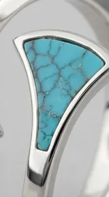 Anillo abierto de plata 925 con diseño geométrico triangular y detalles en piedra turquesa con vetas oscuras.