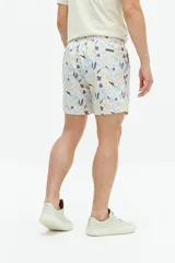 Short de baño con estampado floral en tonos azules, cintura elástica con cordón ajustable, bolsillos laterales y bolsillo trasero.