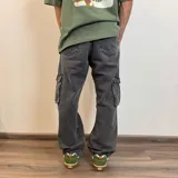 Pantalón jean cargo gris con efecto lavado, corte recto y bolsillos laterales.