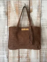 Cartera tipo tote de cuero con textura grabada tipo cocodrilo, color marrón. Cuenta con doble asa de hombro, cierre metálico frontal con detalle de borla y herrajes dorados.