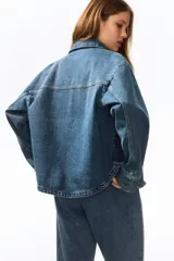 Campera camisera de sarga de algodón con cuello clásico, cierre frontal de botones y dos bolsillos de parche en la parte delantera. Presenta diseño sin forrar y bajo redondeado.
