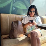 Mochila negra de eco cuero con cierre superior y correas ajustables.