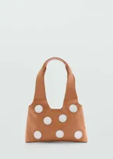 Bolso tipo tote de cuero color marrón claro con apliques de círculos blancos cosidos.