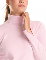 Polera de tejido fino, color rosado, con cuello alto, manga larga y detalle de tajo en los puños.