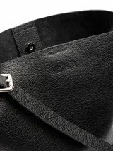 Cartera bandolera de cuero floater color negro, de diseño cilíndrico tipo bucket, con correa larga para llevar al hombro o cruzada y broche de imán.