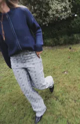 Jean de tiro alto con corte straight flare, confeccionado en denim de algodón con estampado geométrico de rombos y motivos florales en tonos azulados.