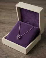 Collar de plata 925 con cadena fina y dije redondo tipo punto de luz, con circonia central en color violeta.