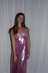 Vestido largo sin mangas con escote en V halter y aberturas laterales (cut-outs) en la cintura. El cuerpo superior presenta un llamativo diseño estampado multicolor, mientras que la falda larga es de tejido texturizado brillante en color verde esmeralda con inserciones godet en el ruedo.