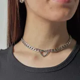 Gargantilla plateada de cadena gruesa con dije de corazón calado.