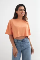 Remera color beige de corte cropped y mangas cortas.