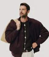 Campera bomber masculina de gamuza sintética color bordó, con cuello camisero, cierre frontal metálico, bolsillos laterales invisibles y rib elástico en puños y ruedo.
