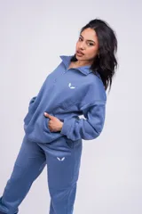 Buzo negro con cierre de media cremallera, cuello alto y logo bordado en el pecho.