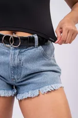 Short de denim tiro alto color celeste con lavado vintage, detalles de tachas aplicadas y ruedo desflecado.