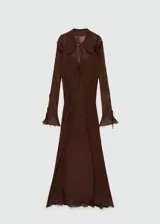 Vestido largo de gasa color marrón, con diseño evasé, cuello camisero y cierre frontal con lazos. Presenta mangas largas y detalles de volados en los hombros.