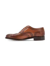 Zapato de vestir tipo Oxford con diseño brogue, confeccionado en cuero vacuno color cognac con acabado degradado en la puntera. Presenta cierre mediante cordones y suela de cuero con tacón bajo.