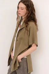 Sobrecamisa roja de lino de manga corta, con cuello solapa, costuras decorativas en contraste y cierre frontal con presillas y botones alargados.