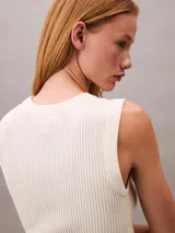 Sweater sin mangas de calce ajustado, confeccionado en tejido de punto acanalado con cuello redondo. Presenta un pequeño bordado con el logo de la marca en el lateral inferior.