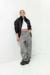 Pantalón de jean gris, corte amplio, tiro bajo y grandes bolsillos traseros.