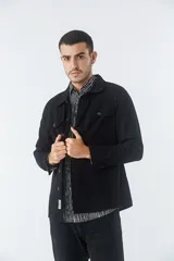 Sobrecamisa de jean color tostado, con cuello clásico, cierre frontal con botones y dos bolsillos frontales con solapa. Presenta mangas largas con puños abotonados y un pequeño parche decorativo en el ruedo.