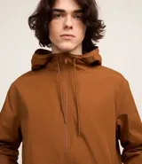 Campera rompevientos color verde oliva con capucha ajustable con cordón, cierre frontal con cremallera, bolsillos laterales con cremallera, puños con elástico y forro interior. Ligera y versátil, ideal para proteger del viento y la lluvia ligera.