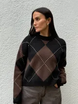 Sweater de punto con diseño de rombos en tonos bordó y beige, cuello redondo y mangas largas con puños acanalados.