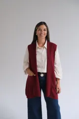 Chaleco largo de punto, sin mangas, con frente abierto y bolsillos laterales aplicados.