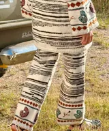 Pantalón tejido a mano en lana merino de corte recto, con diseño de rayas y guarda bordada con motivos florales y geométricos en el bajo.