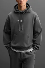 Hoodie gris de corte holgado con efecto desgastado y estampado de graffiti en la espalda.