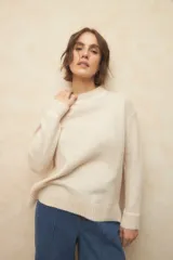 Sweater color crema de cuello alto y manga larga, de corte holgado y tejido suave con lana.