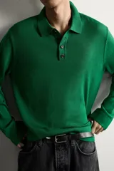 Polo de punto de manga larga en color verde, confeccionado en hilatura de lana. Presenta cuello solapa, cierre frontal con botonadura y acabados en rib en puños y bajo.