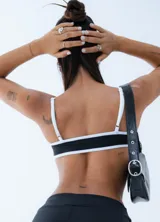 Microtop deportivo de estilo minimalista, color negro con bordes en contraste color blanco. Presenta un diseño de escote redondo y tirantes finos.