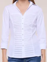 Camisa blanca de poplín de algodón, con silueta semi entallada, cuello camisero con escote en V y pechera frontal con plisado horizontal. Cuenta con abotonadura de strass plateado, mangas tres cuartos con puños anchos vueltos y paneles laterales elásticos.