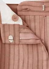 Pantalón de corte recto y tiro medio con diseño de rayas, confeccionado en mezcla de lino y viscosa. Cuenta con detalle de pinzas, trabillas y cierre frontal con cremallera, botón y ganchos ocultos con tapeta.