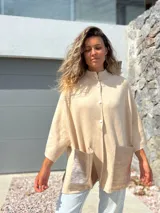 Saco tejido de punto en color crudo, con diseño holgado, mangas tres cuartos y bolsillos frontales grandes confeccionados en cuero metalizado plateado.