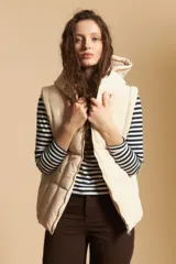 Chaleco acolchado de nylon color negro, con diseño capitoneado, capucha integrada y cierre frontal con tirador metálico.