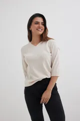 Sweater color beige de tejido de punto, con escote en V y mangas 3/4.