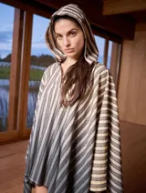 Poncho con capucha a rayas horizontales verdes y blancas, con falda a rayas verticales rosas y marrones.