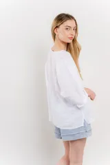 Blusa de lino color verde oliva, de corte amplio y relajado, con escote redondo y mangas 3/4 remangadas.