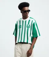 Remera de punto manga corta con diseño rayado vertical en color verde y blanco. Presenta cuello redondo, sisa desplazada y detalles gráficos tipo jersey de fútbol con el número 10 y el logo de la marca Reckless en el frente.